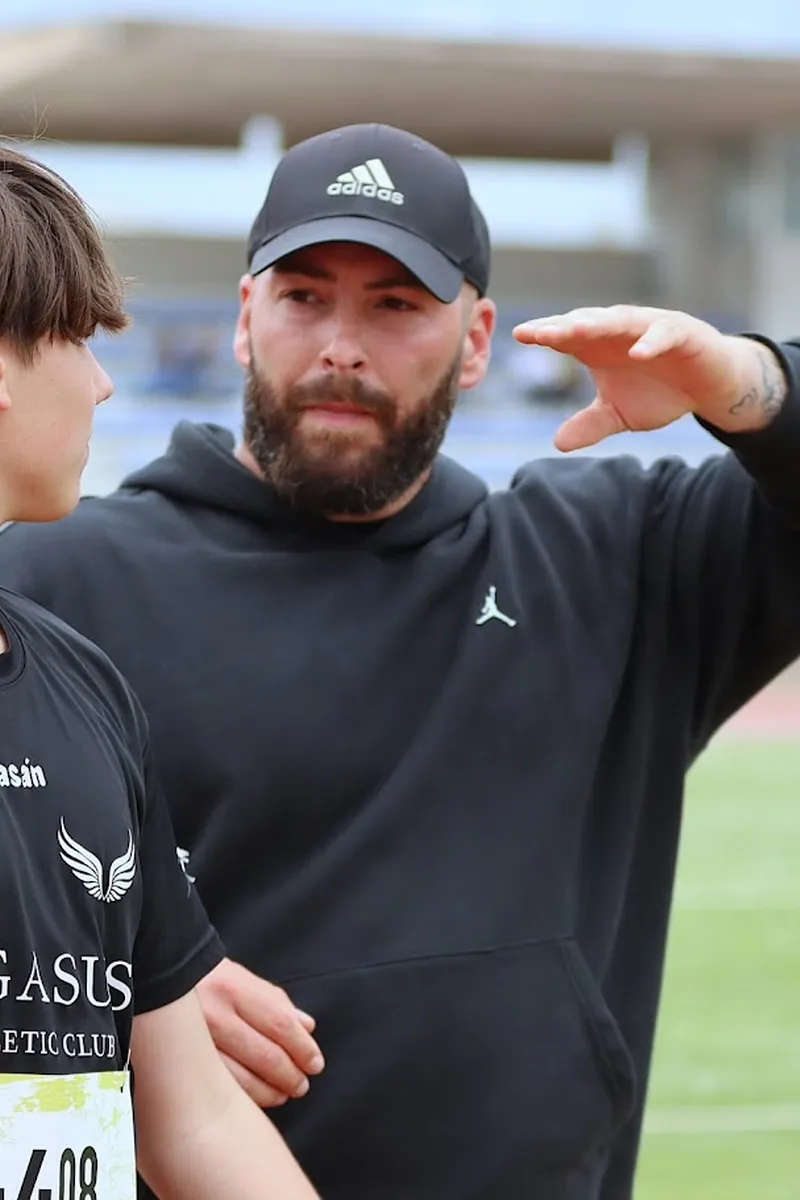 José Ángel Pinedo, director técnico del Club Atletismo Pegasus, con un atleta